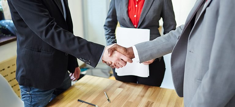 Successful business partners handshaking after signing contract